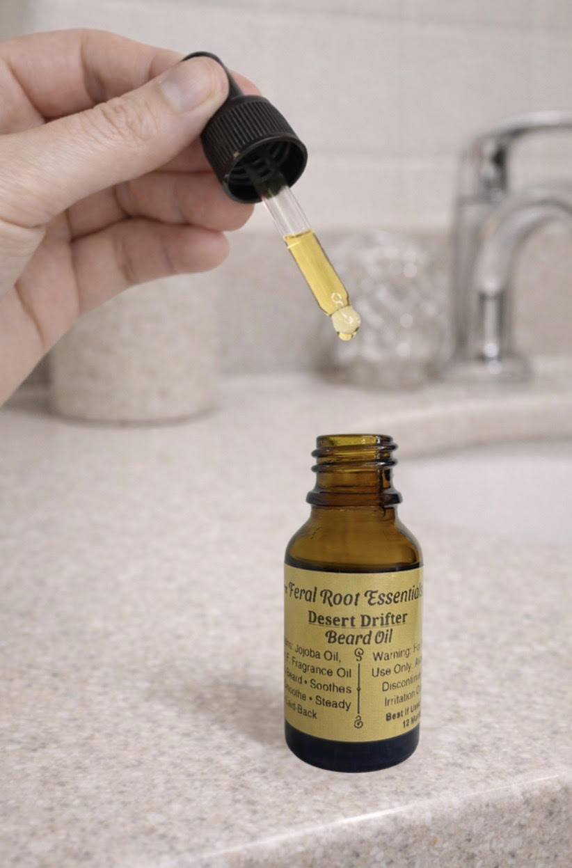 Hand holding a dropper over a bottle of desert drifters beard oil on a bathroom counter.