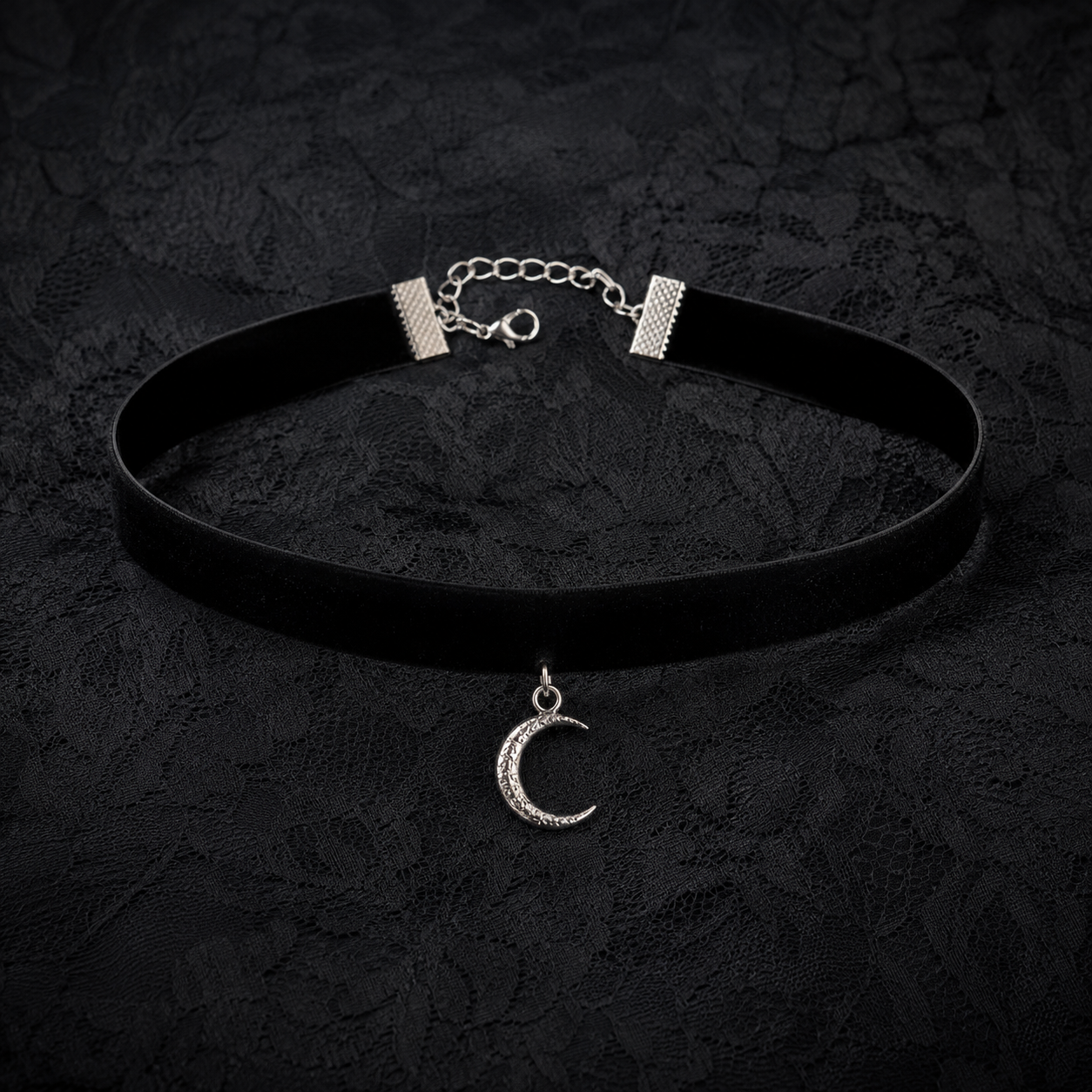 Black velvet choker with silver crescent moon charm on dark lace fabric