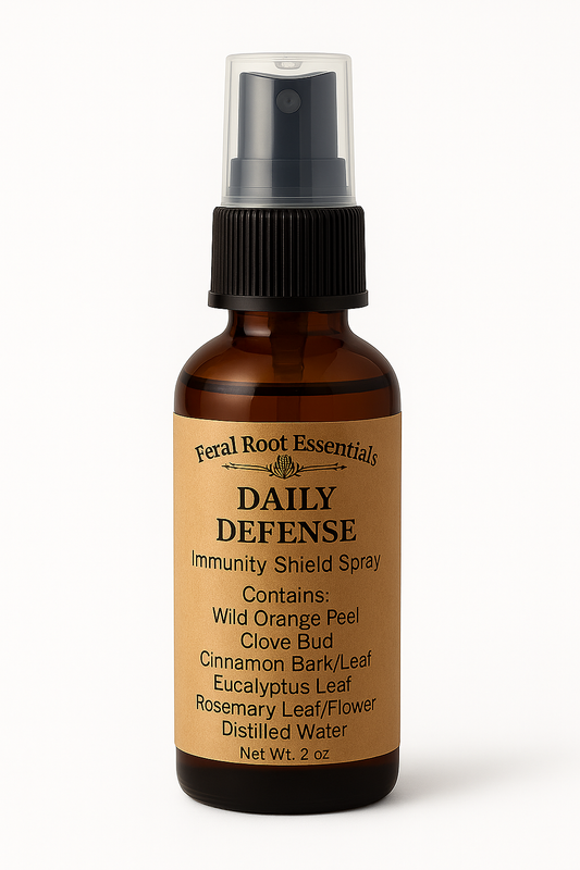 Feral Root Essentials Daily Defense Immunity Shield Spray – 2oz amber glass bottle with tan apothecary label featuring natural ingredients like wild orange peel, clove, cinnamon, and eucalyptus.