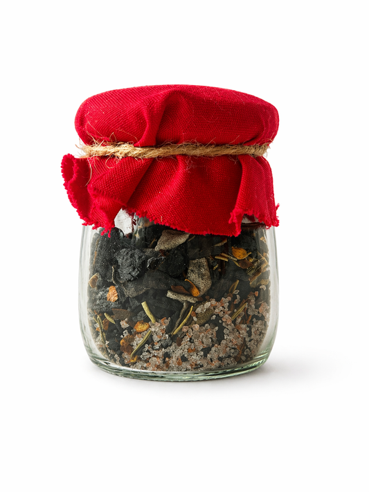 Glass jar with a red cloth lid containing dried herbs on a white background