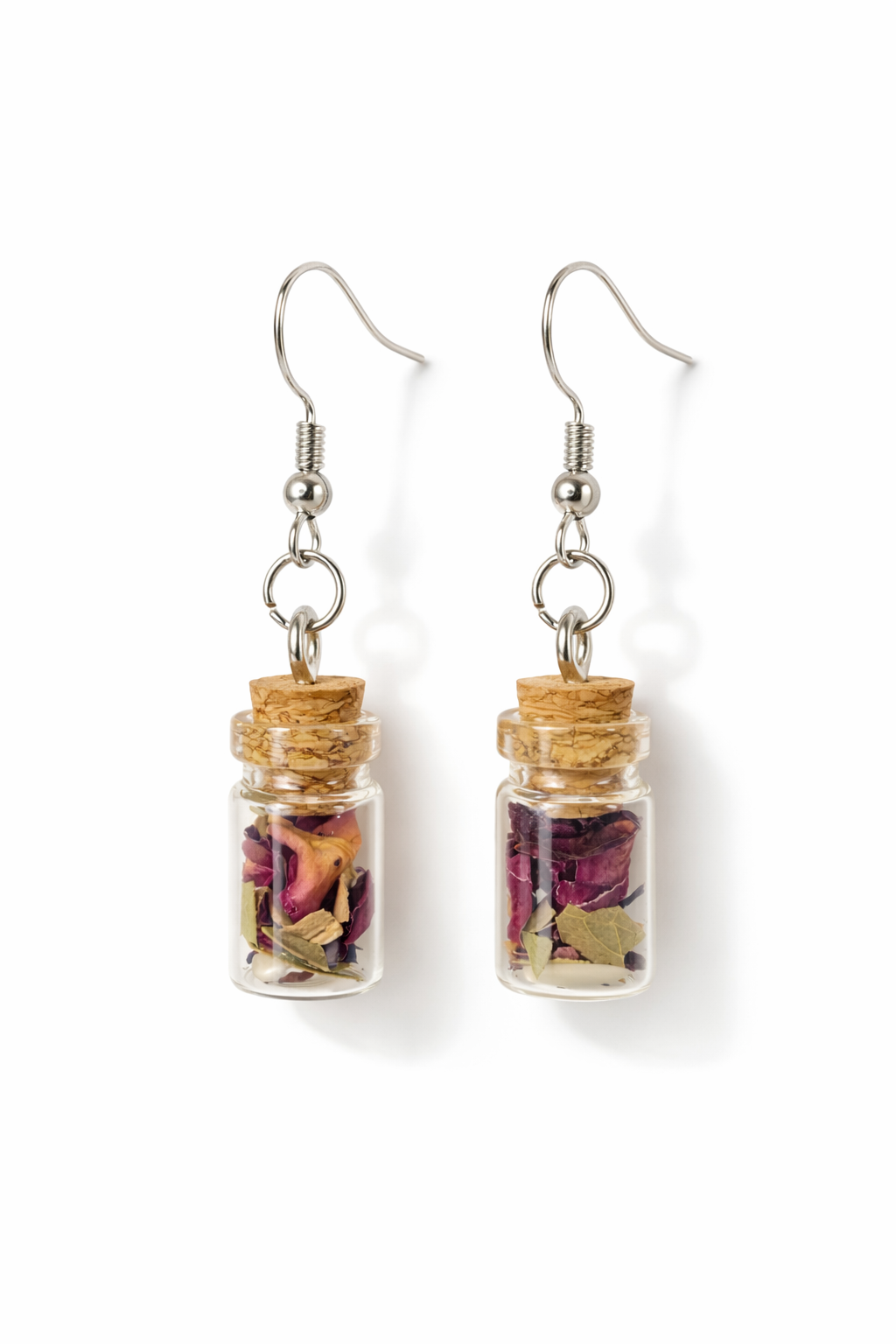 Pair of earrings with small glass jars containing dried flowers on a white background