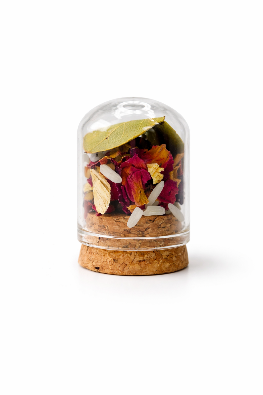 Herbal tea mix in a glass jar with cork lid on a white background