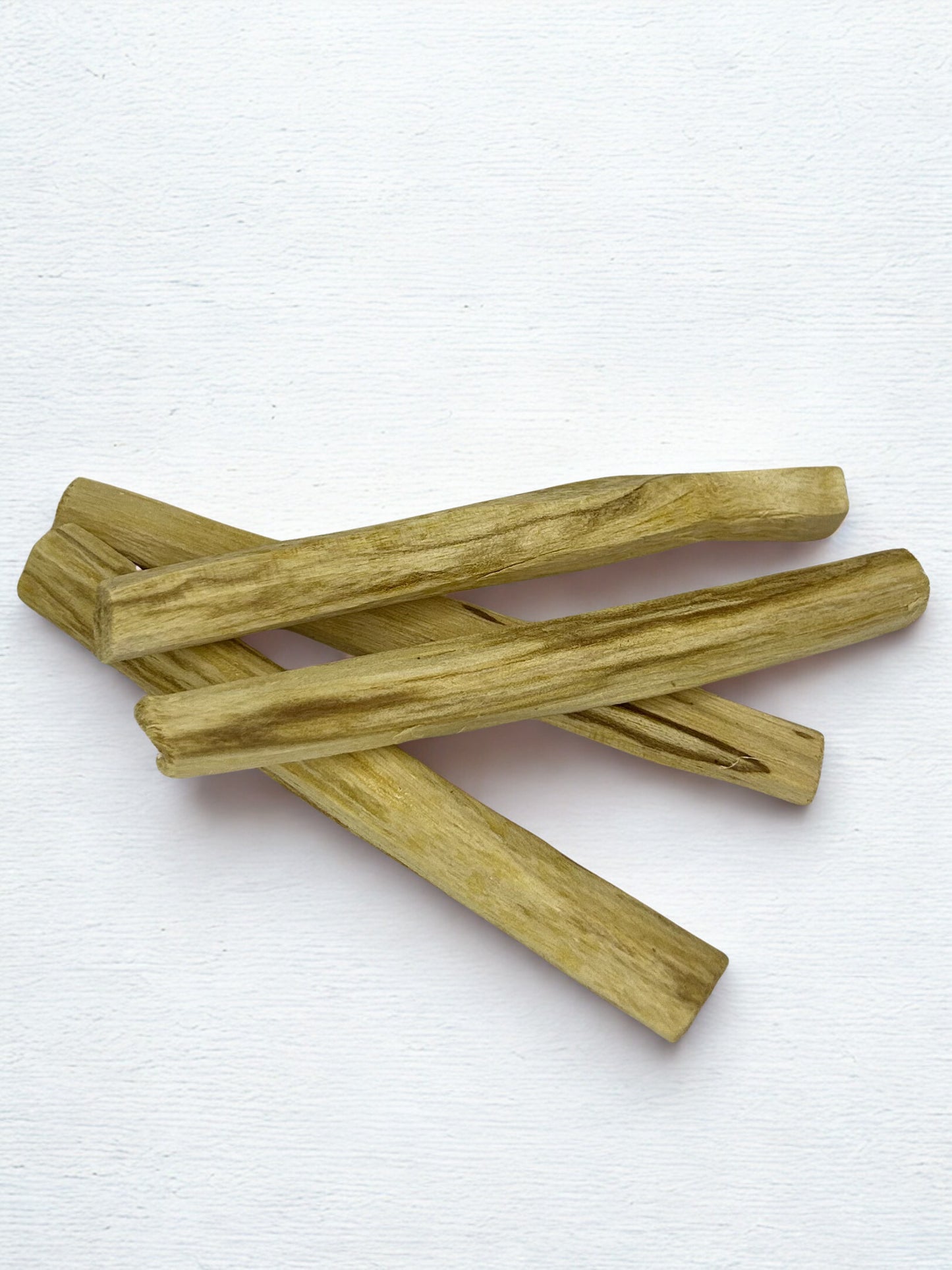 Stack of palo santo sticks on a white background